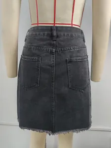 Detailed back view of a black washed denim mini skirt featuring frayed hem and pockets