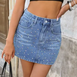 Gros plan sur une mini-jupe en jean bleu ornée de nombreux strass brillants décoratifs