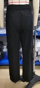 Detailed rear view of black washed denim cargo pants featuring multiple functional storage pockets