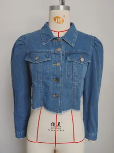 Detailed front view of a cropped blue denim jacket with puff sleeves and raw hem.