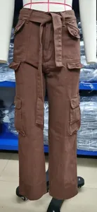 Detail of brown washed denim cargo pants with multi-pockets and matching belt.