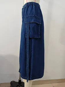 Detail showing cargo pocket and strap on a blue washed denim skirt with elastic waist.