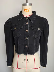 Detail view of black washed denim jacket featuring puff sleeves and raw hem.