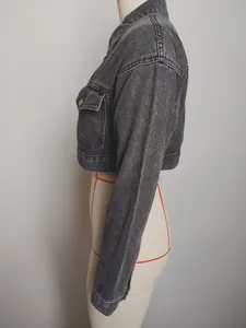 Side profile detail of a vintage washed grey cropped denim jacket on a white dress form