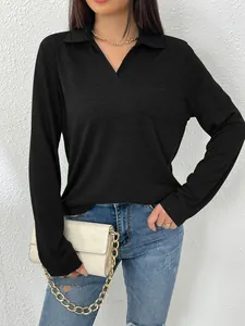 Detailopname van zwart poloshirt met lange mouwen, kraag en voorzakje