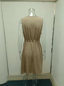 Rear view of a tan sleeveless vest dress with elasticated waist on a clear mannequin.