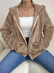 Close-up view of a brown oversized fuzzy teddy fleece hoodie with zip closure and pockets