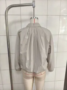 Back view of oversized beige batwing sleeve jacket showing pleated design on mannequin