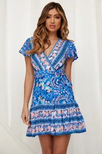 Schönes blaues Mini-Kleid im Boho-Stil mit V-Ausschnitt an einem Frauenmodel
