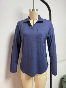Detail van een blauw poloshirt met lange mouwen, een reverskraag en een borstzakje