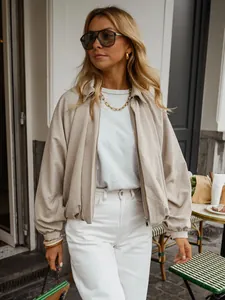 Chic oversized beige batwing sleeve bomber jacket worn by model in an outdoor street setting