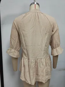 Vista posteriore della blusa albicocca con polsini a balze e vita a pieghe eleganti