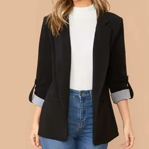 Dettaglio di un blazer nero sfiancato da donna con fodera a righe sui polsini risvoltati