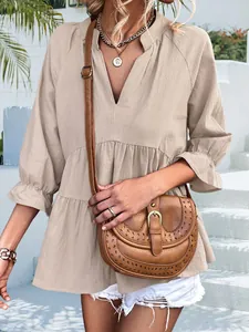 Dettaglio di una camicetta beige con scollo a V e maniche a volant per un look estivo