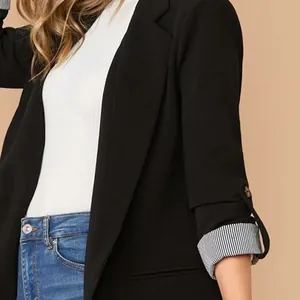 Dettaglio della manica del blazer nero con fodera a righe e accento sul bottone