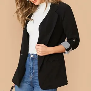 Dettaglio di blazer nero da donna con polsini a righe risvoltati e vestibilità slim.