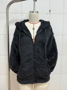 Close-up of the plush texture and zip detail on a black hooded jacket shown on a mannequin