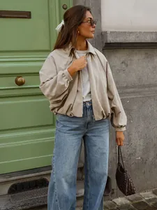 Model wearing oversized beige batwing jacket and wide-leg jeans in street setting