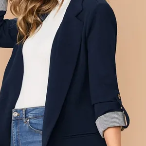 Dettaglio di un blazer blu navy con fodera delle maniche a righe e bottone decor