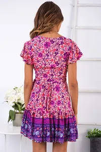 Rückansicht eines rosa-violetten Boho-Kleides mit Blumenmuster und Rüschensaum