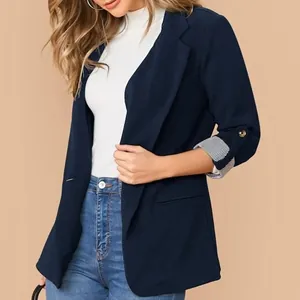 Dettaglio del blazer blu navy con risvolti a righe e maniche a tre quarti.