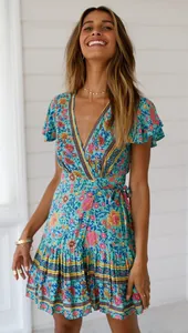 Model trägt ein blaues Blumen-Boho-Wickelkleid mit V-Ausschnitt und gerüschten Ärmeln