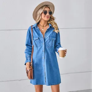 Stylish blonde model wearing a long-sleeved blue washed denim shirt dress outfit