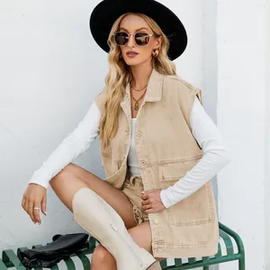 Fashionable women's beige denim sleeveless vest styled with a black hat and white high boots