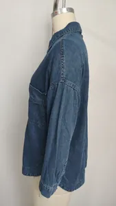Detail view of washed blue denim shirt with retro loose fit design