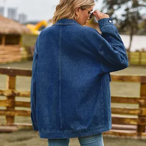 Back view of a vintage oversized blue denim jacket worn in an outdoor farm setting