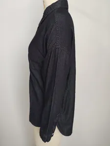 Side view macro detail of a vintage washed black denim shirt with curved side slit