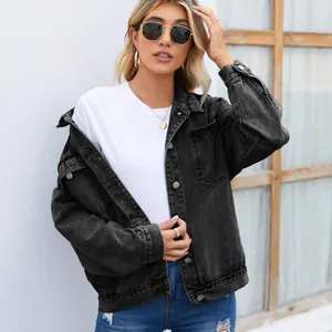 Détail d'une veste en jean noire délavée vintage pour femme avec boutons en métal
