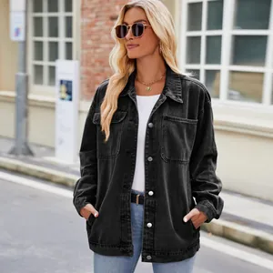 Close-up detail of a vintage black washed denim jacket on a female model outdoors
