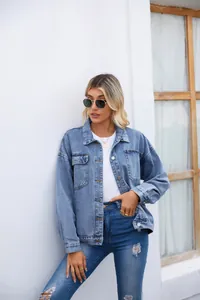 Femme blonde portant une veste en jean délavée bleu clair rétro élégante dans un cadre de vie lumineux.