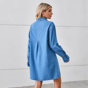 Detail view of loose washed denim shirt dress with back pleat and ruffled cuffs.