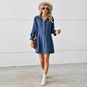Full body view of a stylish long-sleeved washed blue denim dress with button details