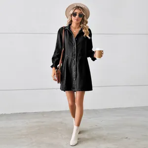 Street style view of a black washed denim long sleeve midi dress with ruffled cuffs