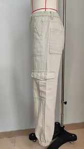 Detail side view of beige cargo pants featuring flap pockets and elastic cuffed hem.