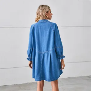 Back view of a loose-fitting washed denim dress with long sleeves and ruffled cuffs