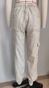 Back view of beige cargo jogger pants featuring elastic waist and large utility pockets