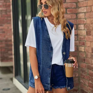 Λεπτομέρεια ενός oversized μπλε τζιν γιλέκου με ασημένια κουμπιά και τσέπες.