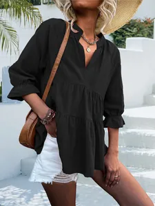 Dettaglio lifestyle di un top nero casual con scollo a V e maniche lunghe con volant