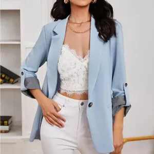 Dettaglio di un blazer azzurro che mostra l'elegante fodera a righe sui polsini risvoltati