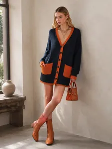 Close-up of woman wearing V-neck knit cardigan with orange color-block contrast trim