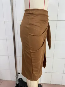 Detail of elegant brown suede midi skirt with side knot and wrap design.