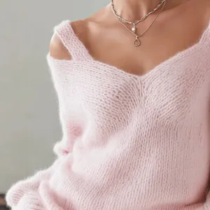 Primer plano detallado que muestra la suave textura de mohair de este suéter rosa con cuello en V