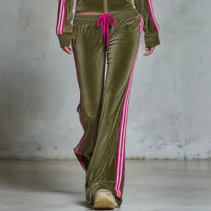 Detailed view of olive green velvet tracksuit featuring pink and white side stripes and wide legs