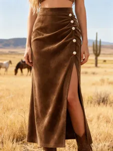 Close-up of high-waisted brown suede midi skirt with side slit and pearl buttons