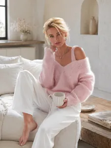 Jersey de mohair rosa con cuello en V y hombros descubiertos en un ambiente acogedor.