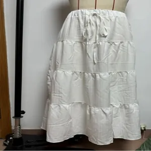 Detailed view of white tiered midi skirt featuring a drawstring waist and flowing layers